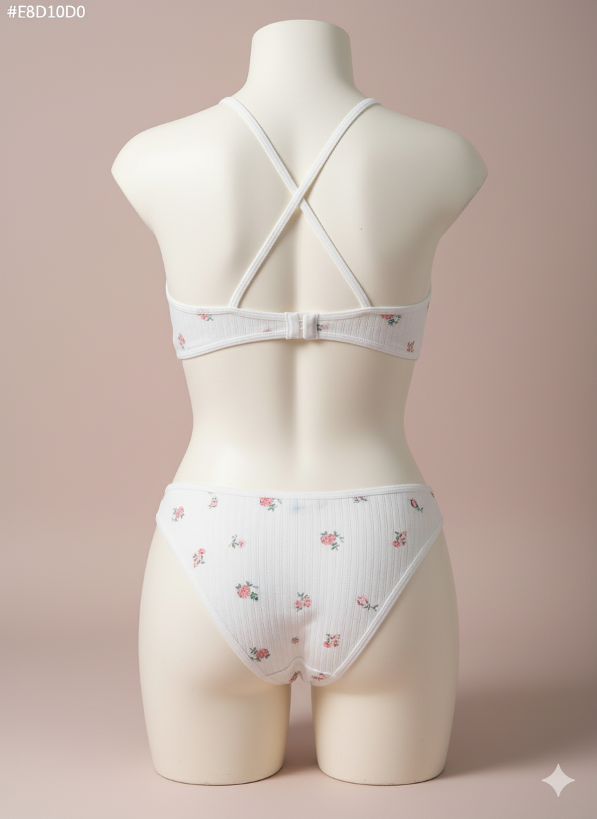 A charming and cozy two-piece set crafted from a comfortable ribbed knit fabric. It features a delicate all-over floral print, a wide underband bralette with crisscross back straps, and a matching thong panty for soft, everyday comfort.