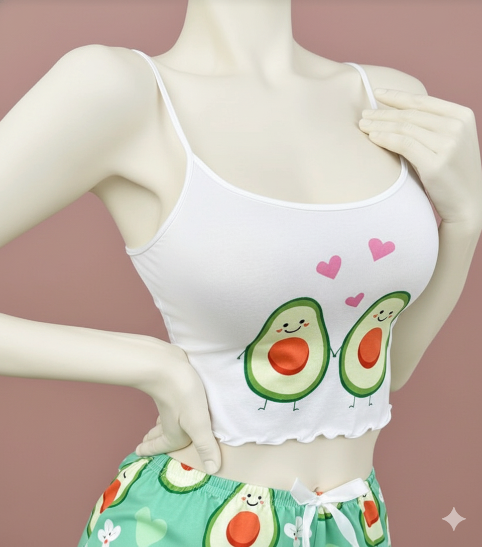 An adorable cropped cami top featuring a fun, stylized fruit graphic print and delicate lettuce-edge trim along the hemline. Designed with thin, adjustable spaghetti straps for a personalized, comfortable fit.