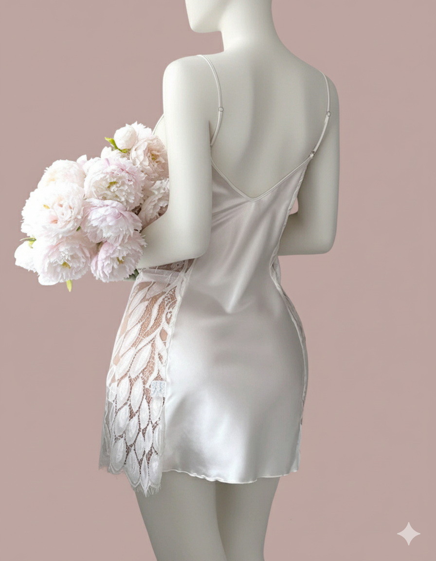 Indulge in luxury with this stunning short slip dress chemise. It features a draped cowl neckline, delicate spaghetti straps, and elegant sheer lace panels on the sides for a beautiful, captivating look.