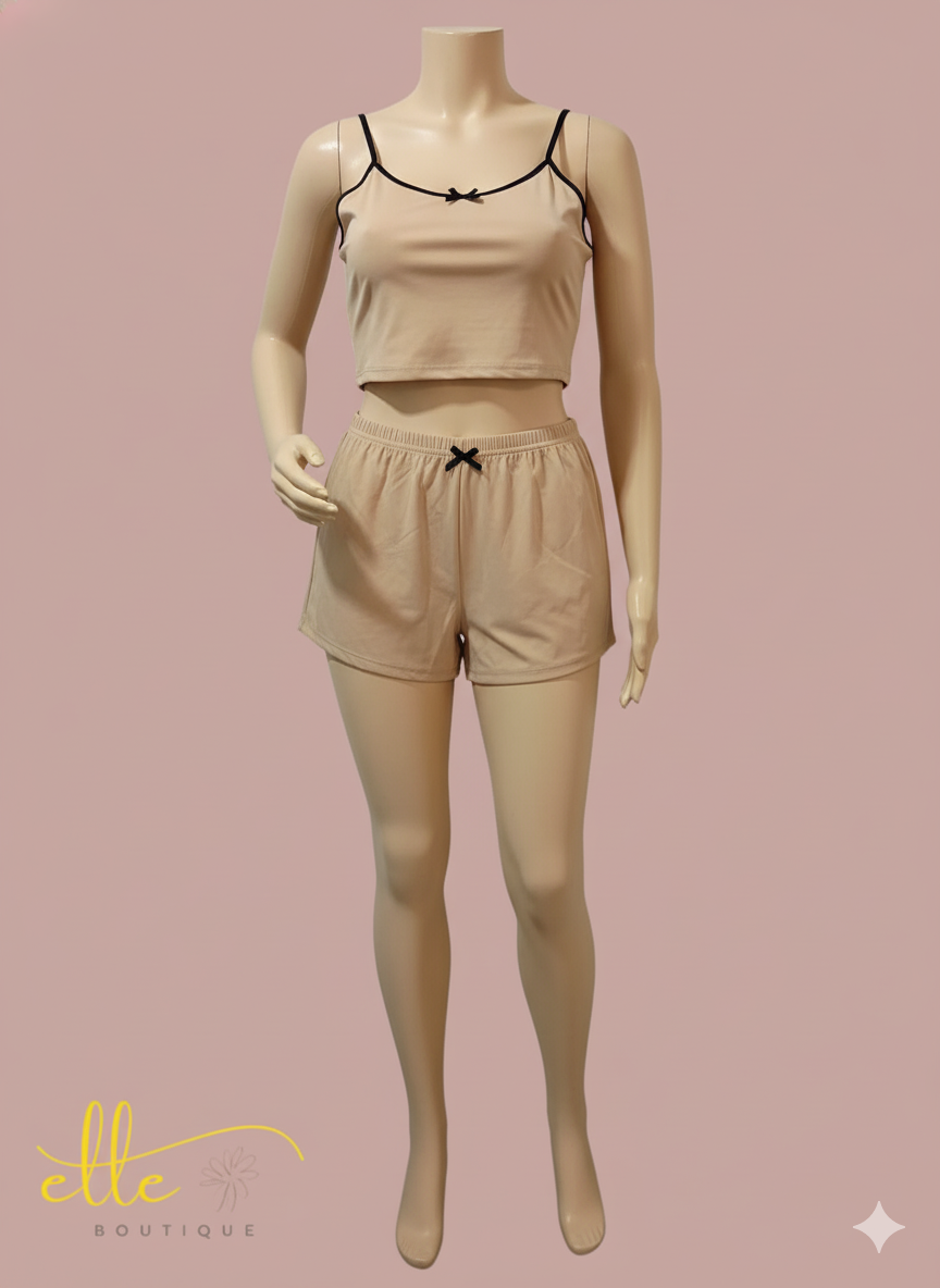 Relax in style with this comfortable two-piece loungewear set. It includes a cropped cami top with delicate spaghetti straps and matching elastic-waist shorts, both adorned with small bow details for a touch of charm.