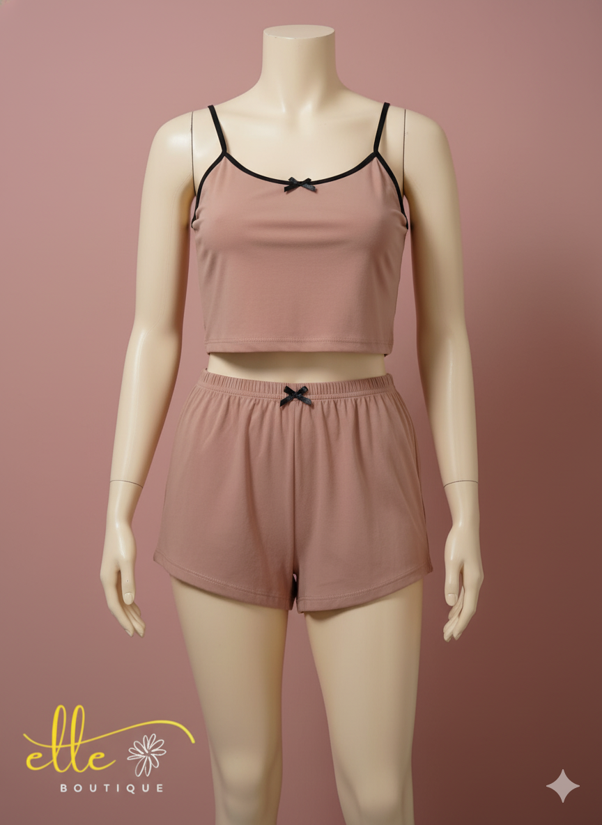 Relax in style with this comfortable two-piece loungewear set. It includes a cropped cami top with delicate spaghetti straps and matching elastic-waist shorts, both adorned with small bow details for a touch of charm.