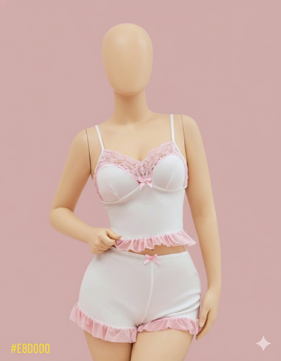 An irresistibly cute two-piece sleep set featuring a cami top and matching shorts. Designed with delicate lace trim on the bust and playful ruffled hems for a charming and comfortable night's rest.